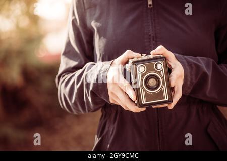 Girl is holding a vintage camera in her hands Stock Photo