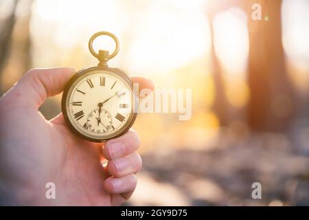 Hand held stop watch outdoors, autumn, blurry background Stock Photo