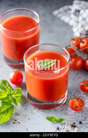 Tomato juice with salt and basil on concrete background. Healthy detox tomato juice Stock Photo