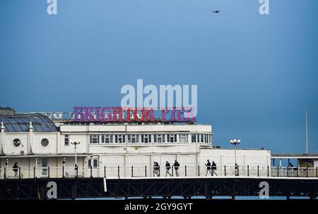 Brighton UK 7th October 2021 - Visitors enjoy a walk on an overcast afternoon along Brighton Palace Pier as warm weather is forecast for the next few days in parts of the UK : Credit Simon Dack / Alamy Live News Stock Photo