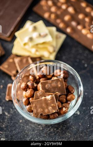 Chocolate bar with hazelnuts on black table. Stock Photo