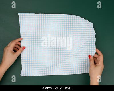 two female hands hold blank sheets of paper in a box, a place for an inscription Stock Photo