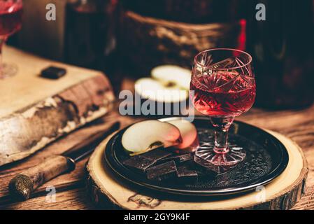 Homemade red currant nalivka and chocolate with sliced apple on metal tray Stock Photo