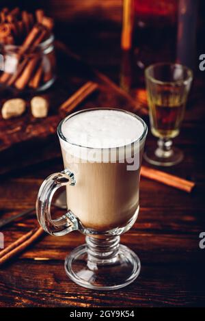 Irish coffee in drinking glass on wooden surface Stock Photo