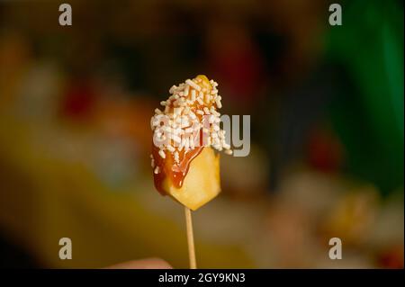 Detail of Candy apple on a stick in selective focus Stock Photo