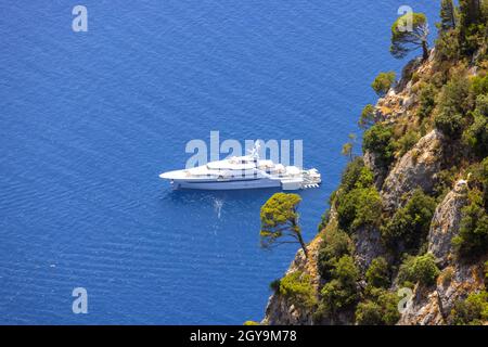 Picturesque view of the Tyrrhenian Sea near the beach Marina Piccola, a luxury yacht on background of blue water, Capri, Naples, Italy Stock Photo