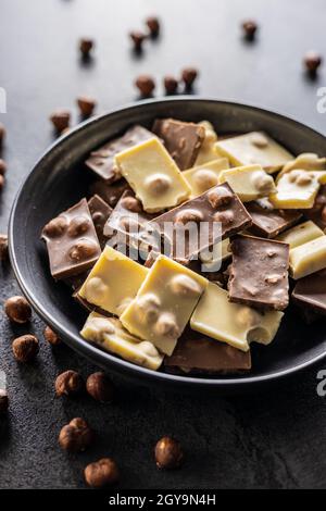 Nutty white and dark chocolate with hazelnuts on plate. Stock Photo