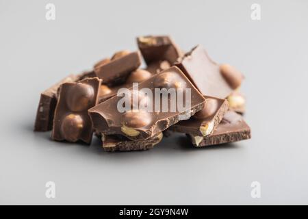 Nutty chocolate with hazelnuts on gray background. Stock Photo