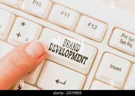 Sign displaying Brand Development, Internet Concept improving customers knowledge and opinions of a brand Lady finger showing-pressing keyboard keys-b Stock Photo