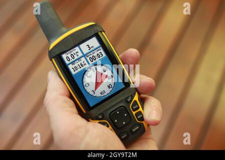 compass on the screen of a tourist  gps navigator in a man's hand Stock Photo