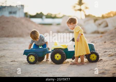 Children playing together with toy tractor Stock Photo