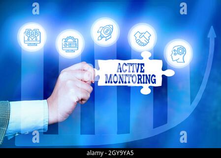 Hand writing sign Active Monitoring, Internet Concept person incharge go out and check workplace conditions Hand Holding Jigsaw Puzzle Piece Unlocking Stock Photo