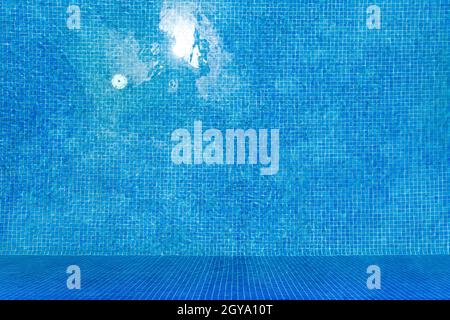 Top view of clear water in a blue tile swimming pool background. Stock Photo