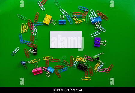 pile of paper clips isolated on green background, documents, office supplies concept, dirty office desk. Empty place for writing and text. Top view, l Stock Photo