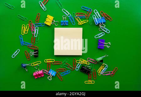 pile of paper clips isolated on green background, documents, office supplies concept, dirty office desk. Empty place for writing and text. Top view, l Stock Photo