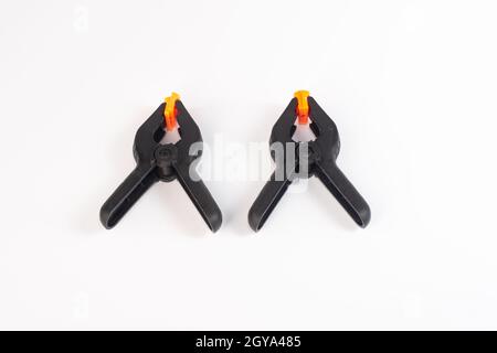 Two black construction clothespins on a white background.  Stock Photo