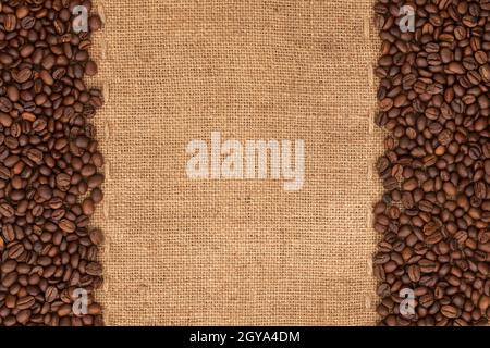 Coffee beans lying on sackcloth with space for text Stock Photo