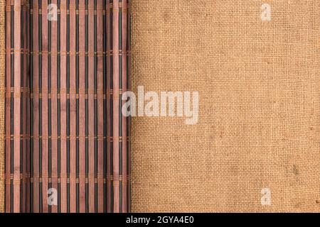 Bamboo mat twisted in the form of a manuscript on sackcloth, with space for your text Stock Photo