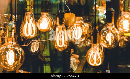 Many different vintage light bulbs hanging . Decorative hanging ceiling light.Decorative antique Edison style light bulbs against brick wall backgroun Stock Photo
