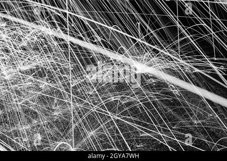 Black and white sparks against a pavement ground Stock Photo