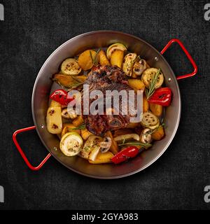 Flat lay of crispy roasted pork knuckle served with roasted vegetables Stock Photo