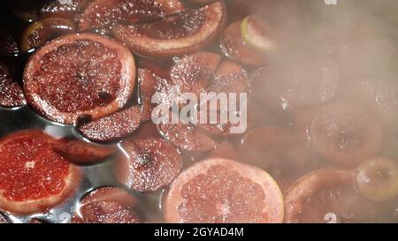 Mulled wine cooked on a fire outside. Close up. Vitamins in a winter drink. Street eatery. Hot mulled wine. Dense steam over cauldrons of hot wine Stock Photo