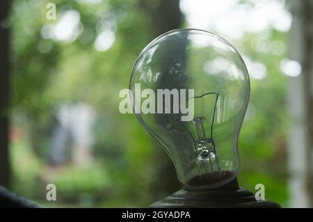 Closeup filament of Older style Incandescent Clear Light bulb isolated from background. Stock Photo