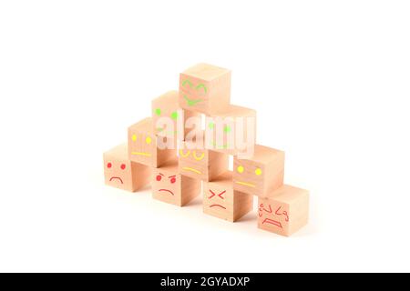 Wooden geometric piramid of cubes with painted faces evaluation increase of happy, from sad to happy.  Isolated on a white background. High resolution Stock Photo