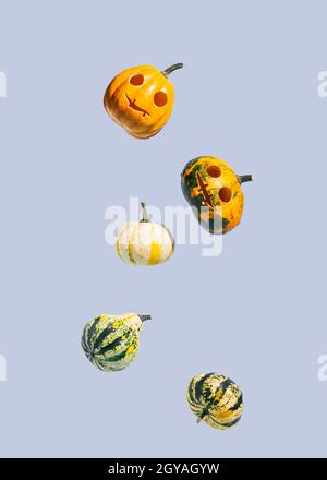 Falling Halloween pumpkins isolated on a blue background. Upright rectangle with copy space Stock Photo