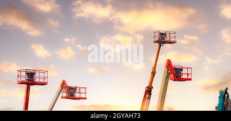 Articulated boom lift. Aerial platform lift. Telescopic boom lift against the sky. Mobile construction crane for rent and sale. Maintenance and repair Stock Photo