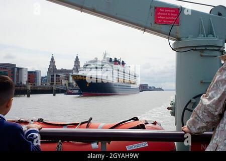 View from the Mersey ferry Snowdrop on the river looking back towards the cruiseship terminal with a Disney ship moored Stock Photo