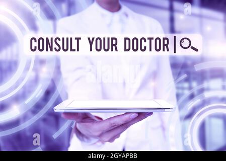 Handwriting text Consult Your Doctor, Conceptual photo ask information or advice from a medical professional Lady Uniform Standing Tablet Hand Present Stock Photo