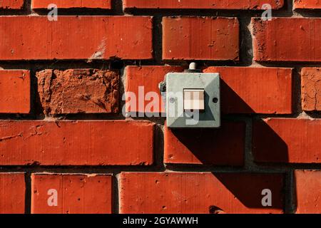 Old waterproof electricity switch mounted on house outer brick wall, copy space included Stock Photo