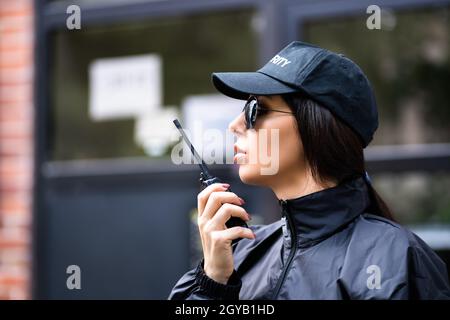Professional Security Guard Officer Using Walkie Talkie Stock Photo