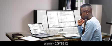 African American Coder Using Computer At Desk. Web Developer Stock Photo