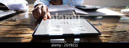 E Invoice Receipt On Tablet Computer. Accountant Manager Checking Bills Stock Photo