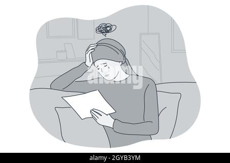 Sadness, mental depression, bad news concept. Young unhappy crying woman sitting and reading letter with bed news and suffering from depressed state o Stock Photo