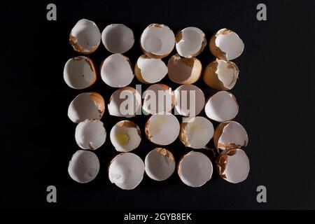 top view of eggshells in row on black background Stock Photo