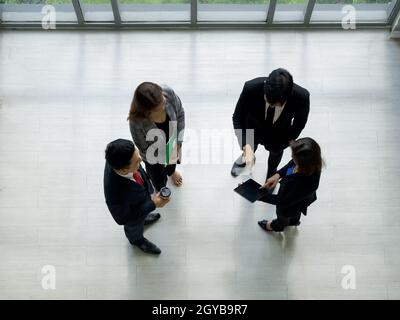 A group of businessmen discussing work in the hall of a modern office. People corporate business team concept. Top View Stock Photo