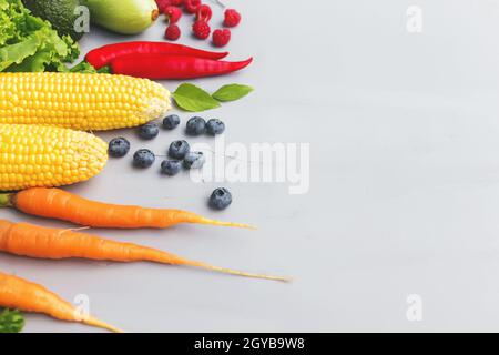 Flat lay with different vegetables, fruits, berries, herbs. Copy space area for some text. Veggies on grey concrete background. Concept of organic bio Stock Photo