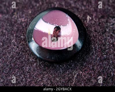 Colored button on a woolen cloth coat. Tailoring. Place for text. Background image. Stock Photo