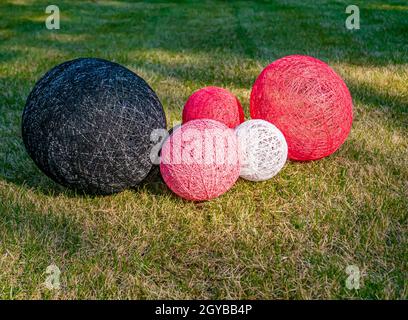 Colored balls of wound thread on a grassy lawn. Design. Background image. Place for text. Interior. Stock Photo