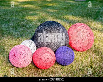 Colored balls of wound thread on a grassy lawn. Design. Background image. Place for text. Interior. Stock Photo