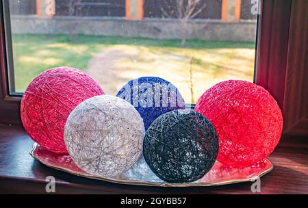 Colored balls of wound thread on a windowsill. Design. Background image. Place for text. Interior. Stock Photo