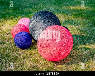 Colored balls of wound thread on a grassy lawn. Design. Background image. Place for text. Interior. Stock Photo