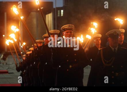 Berlin, Germany. 07th Oct, 2021. Soldiers of the Guard Battalion of the German Armed Forces stand with torches in the courtyard of honour of the Federal Ministry of Defence. The soldiers take part in a serenade in honour of Peter Tauber, former Parliamentary State Secretary. Credit: Wolfgang Kumm/dpa/Alamy Live News Stock Photo
