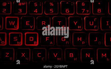 Black computer keyboard with red backlight in the dark. Laptop keyboard. Electronic technology. Background image. Typing. Abstraction. Stock Photo