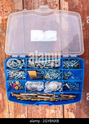 Working tool plastic case with bolts and nuts. Threaded connection of metal parts. Parts fastening technology. Drill bits. Locksmith accessories. Back Stock Photo