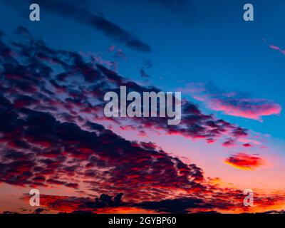 Red sunset on a cloudy blue sky with clouds. Pink evening dawn. Morning red pink sunshine dawn. Clouds in the blue sky. Pink morning dawn. Heavenly la Stock Photo