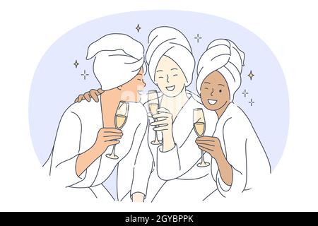 Bride and friends party, pajama party with friends concept. Young smiling multiethnic girls with glasses of champagne in towels and home clothing havi Stock Photo